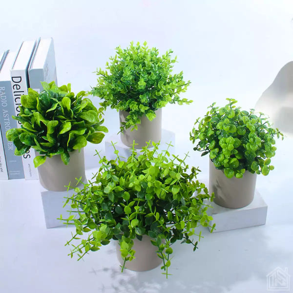Mini plantas artificiais Maisonelle® em vasos brancos, exibindo acabamento realista e design sofisticado para decoração.