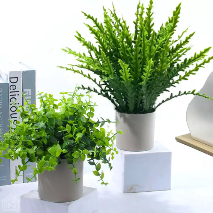 Mini plantas artificiais para decoração com design sofisticado e acabamento realista em vasos brancos sobre bancada.