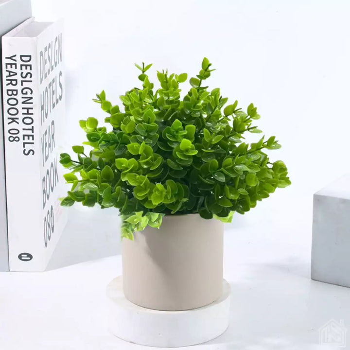 Mini planta artificial com acabamento realista em vaso bege, ideal para decoração de ambientes.