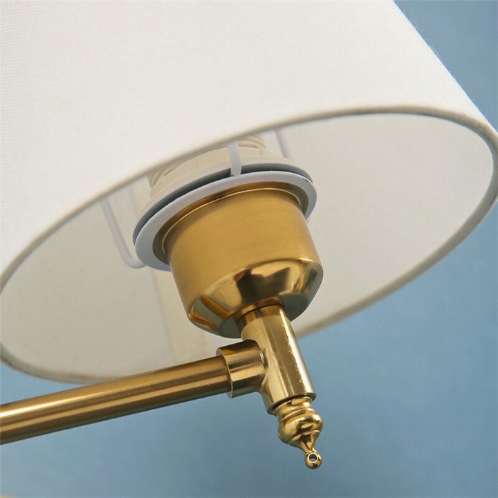 Detalhe de perto da base e soquete de uma arandela de parede dourada