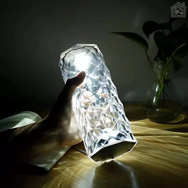 vista-lateral-luminaria-de-mesa-led-cristal-segurando-na-mao