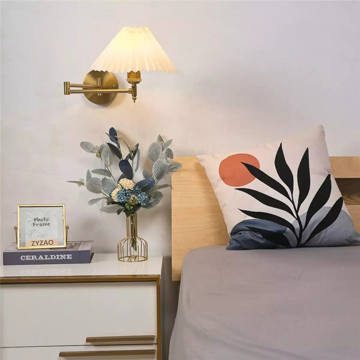 Luminária plissada dourada em um ambiente sofisticado de quarto sobre um criado-mudo