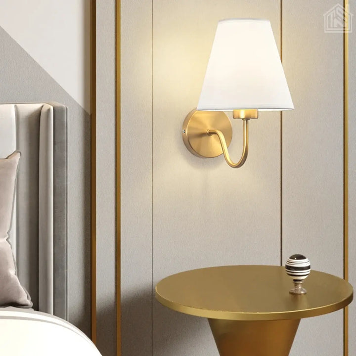 luminária-de-parede-cúpula-branca-com-suporte-dourado-em-cima-de-uma-mesa-de-cabeceira-em-um-quarto-moderno