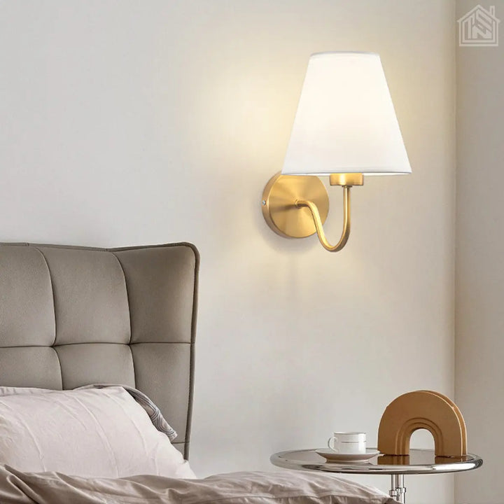 luminária-de-parede-cúpula-branca-com-suporte-dourado-em-um-quarto-neutro-ao-lado-de-uma-cama